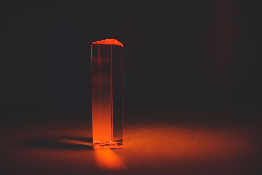 Translucent vertical form glowing red and orange against a dark background.